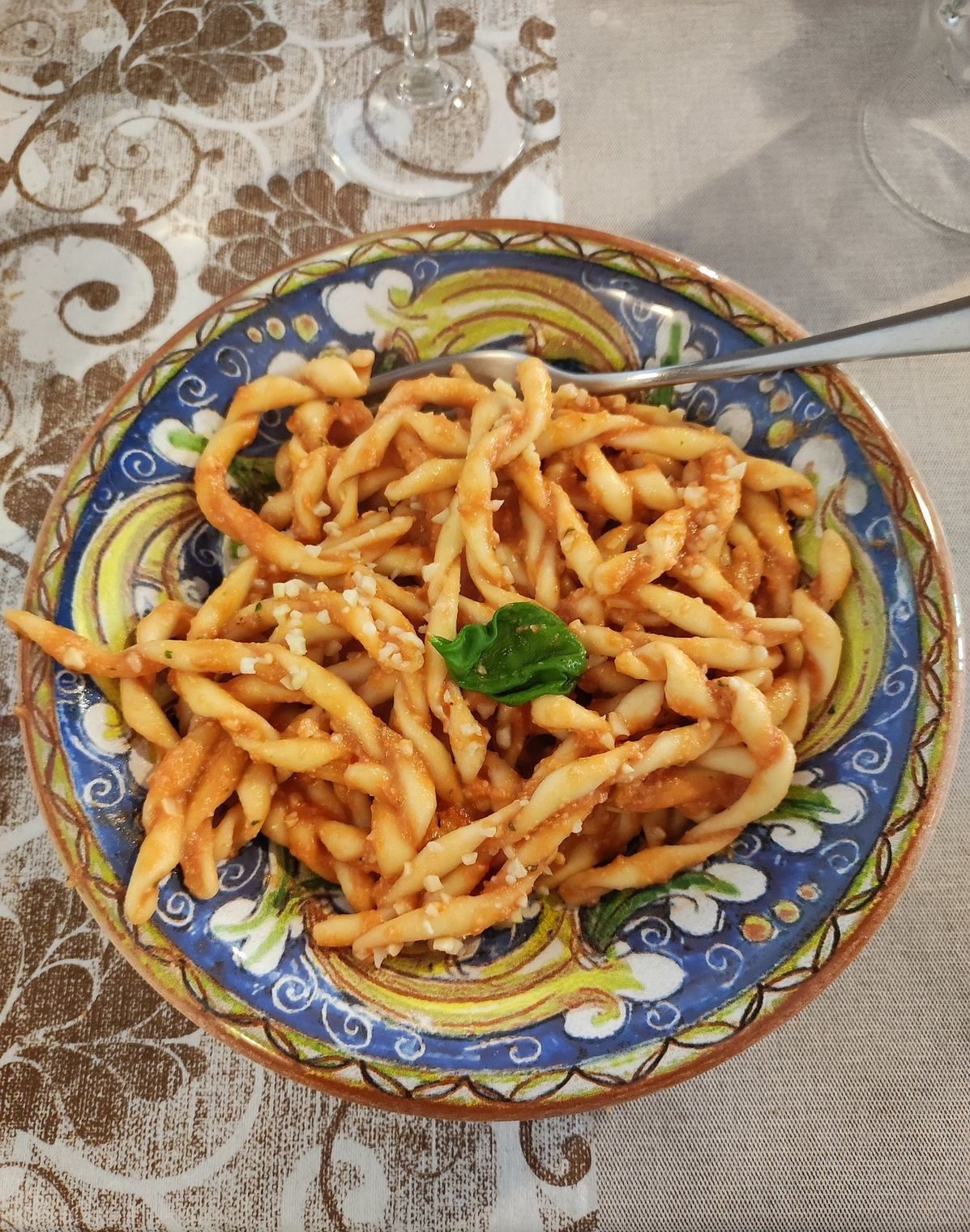 Pasta fresca al pomodoro e basilico in un piatto di ceramica siciliana